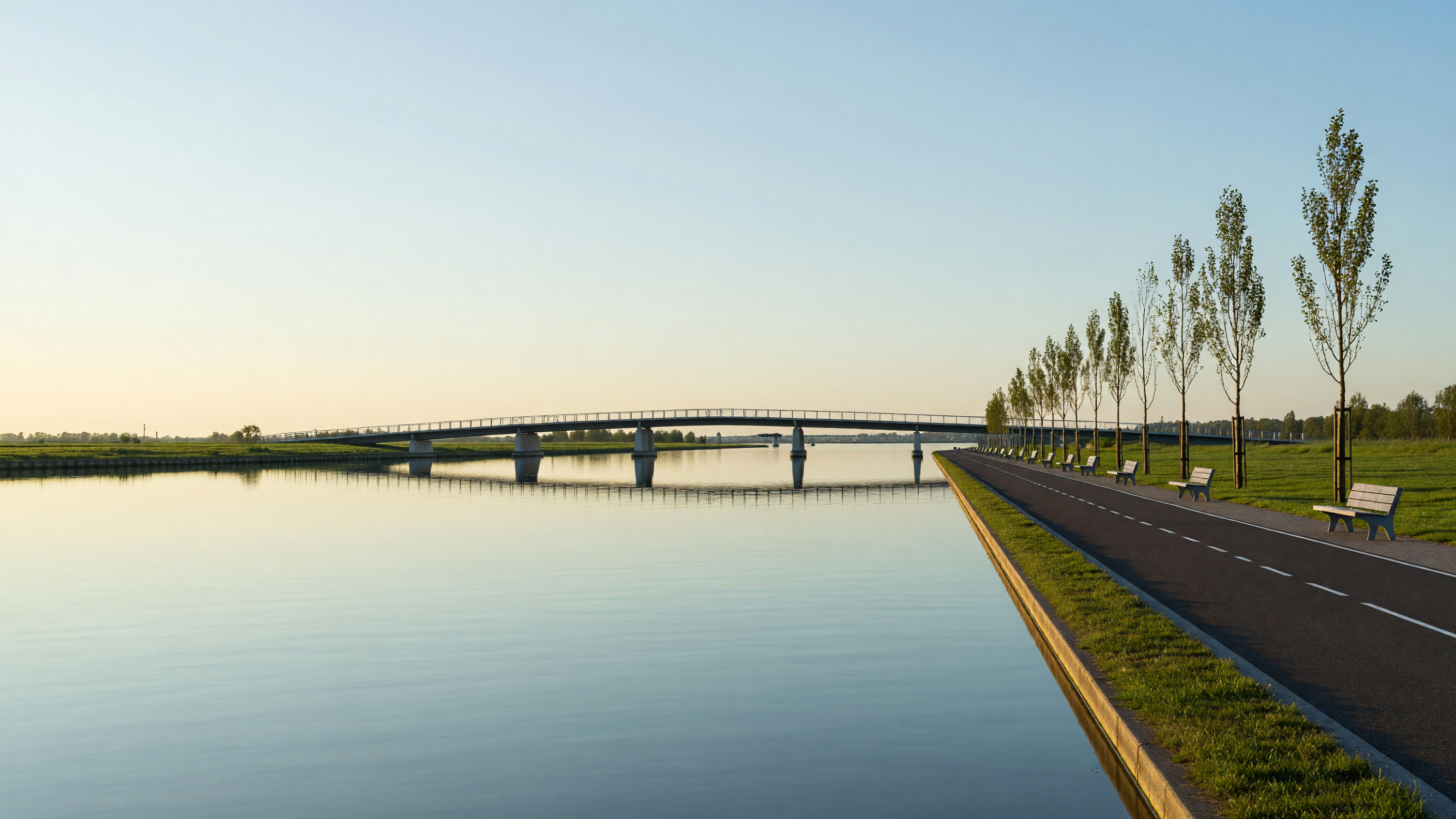 A quiet sunrise view of the Amsterdam-Rijnkanaal in Maarssen, showing the logistical divide of the town.