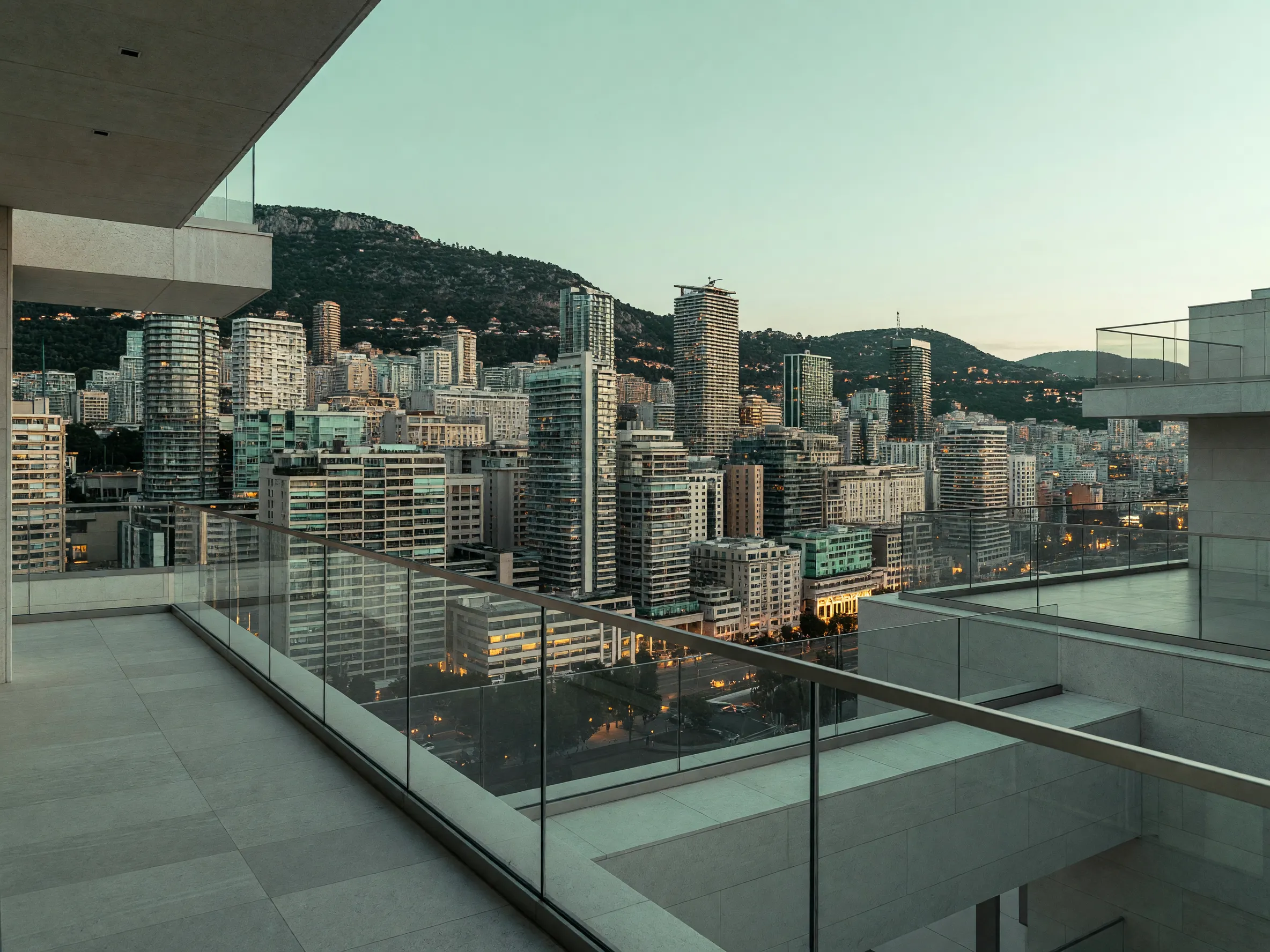 Wide view from a Monte Carlo penthouse balcony at twilight overlooking the city skyline.